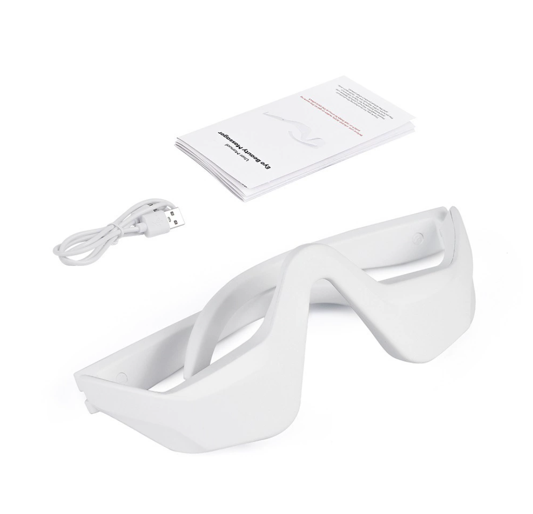 White electronic EMS Microcurrent Eye Massager Devicewith USB cable and user manual on a white background