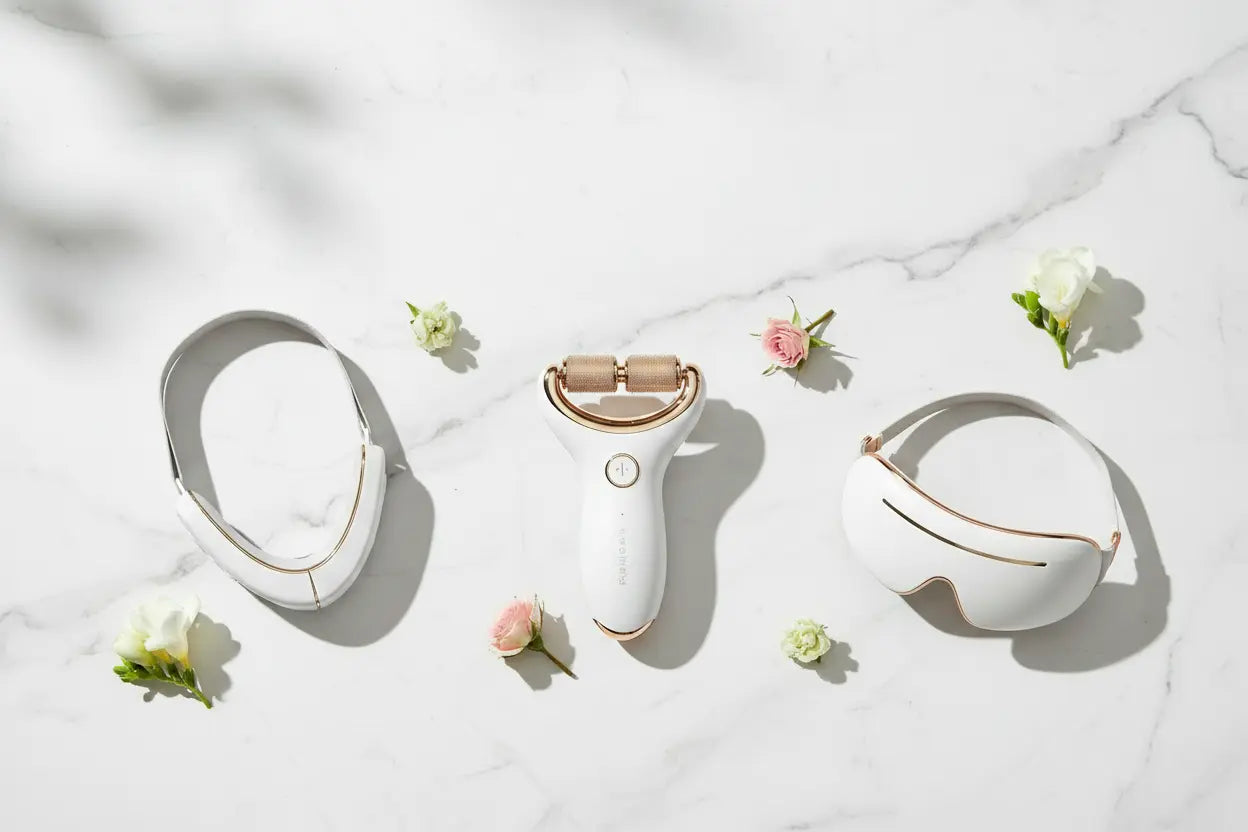 Beauty device with a white case on a light marble background with flowers.